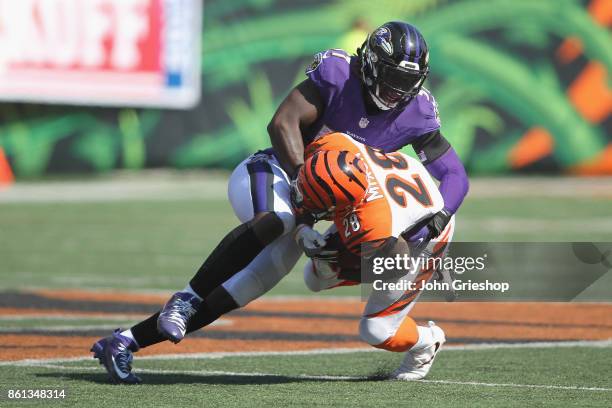 Joe Mixon of the Cincinnati Bengals runs the football upfield against C.J. Mosley of the Baltimore Ravens during their game at Paul Brown Stadium on...