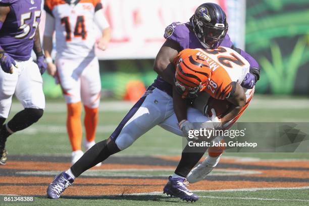 Joe Mixon of the Cincinnati Bengals runs the football upfield against C.J. Mosley of the Baltimore Ravens during their game at Paul Brown Stadium on...