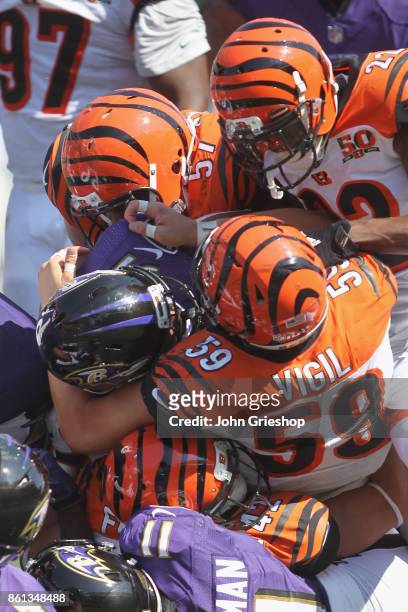 Vincent Rey, Nick Vigil and William Jackson of the Cincinnati Bengals make the tackle on Javorius Allen of the Baltimore Ravens during their game at...