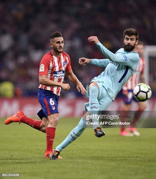 Barcelona's Spanish defender Gerard Pique vies with Atletico Madrid's Spanish midfielder Koke during the Spanish league football match Club Atletico...