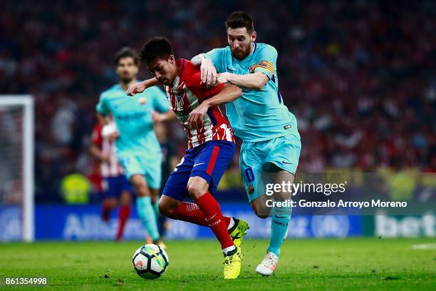 Nicolas Gaitan of Atletico de Madrid competes for the ball with Lionel Messi of FC Barcelona during the La Liga match between Club Atletico Madrid...