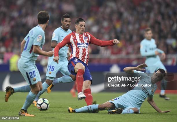 Atletico Madrid's Spanish forward Fernando Torres vies with Barcelona's Spanish midfielder Sergio Busquets during the Spanish league football match...