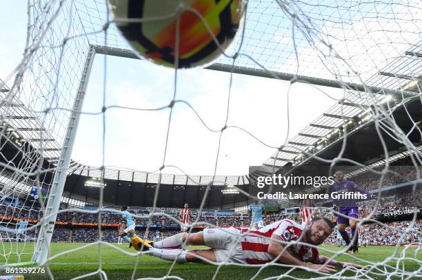 Raheem Sterling of Manchester City scores his sides second goal as Erik Pieters of Stoke City attempts to clear off the line during the Premier...