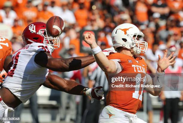 Ogbonnia Okoronkwo of the Oklahoma Sooners forces a fumble by Sam Ehlinger of the Texas Longhorns in the first quarter at Cotton Bowl on October 14,...