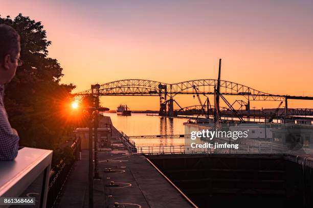 sault ste. marie bridge in dusk - great lakes freighter stock pictures, royalty-free photos & images