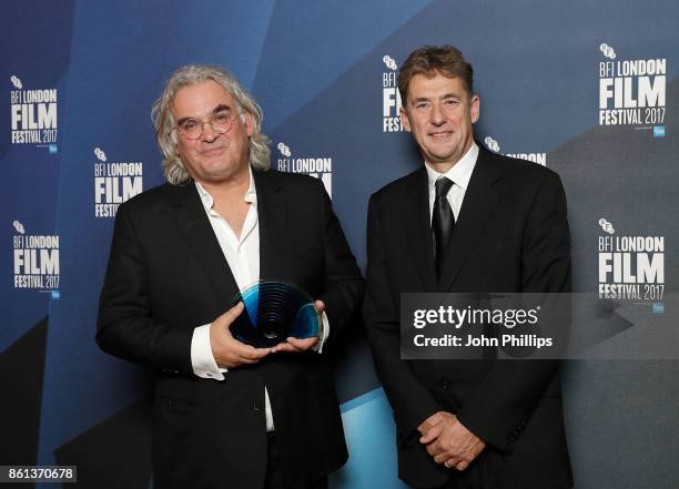 Paul Greengrass poses in the winners room with his BFI Fellowship award and award presenter Tim Bevan at the 61st BFI London Film Festival Awards on...