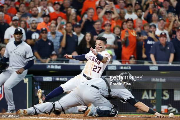 Jose Altuve of the Houston Astros slides home to score the winning run against Gary Sanchez of the New York Yankees in the ninth inning during game...