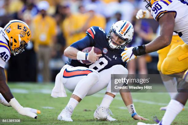 Caleb Lewis of the Auburn Tigers is hit after running the ball by Arden Key and Rashard Lawrence of the LSU Tigers at Tiger Stadium on October 14,...