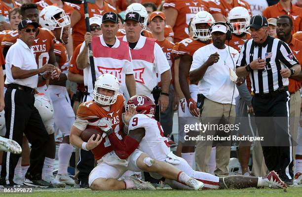 Sam Ehlinger of the Texas Longhorns is tackled by Kenneth Murray of the Oklahoma Sooners near the Texas sideline in the fourth quarter at Cotton Bowl...