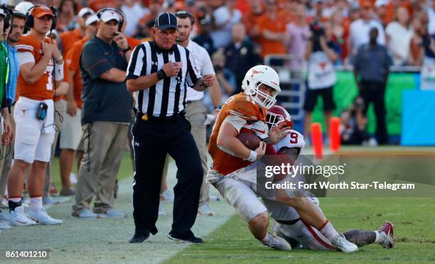 Texas quarterback Sam Ehlinger is hit at the sidelines by Oklahoma linebacker Kenneth Murray in the fourth quarter in the annual Red River Showdown...