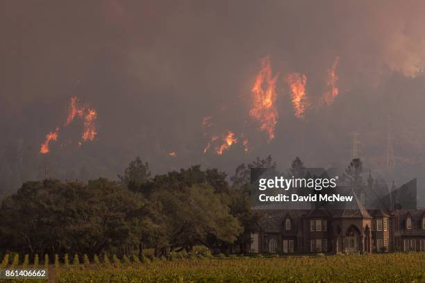 Flames rise behind Ledson Winery on October 14, 2017 in Kenwood, near Santa Rosa, California. At least 40 people are confirmed dead with hundreds...