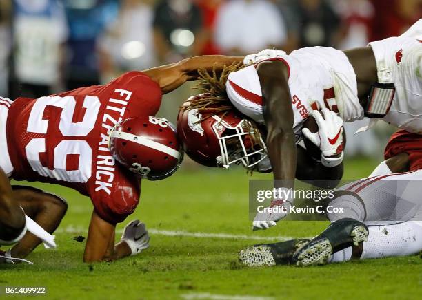 Ronnie Harrison and Minkah Fitzpatrick of the Alabama Crimson Tide tackle Brandon Martin of the Arkansas Razorbacks at Bryant-Denny Stadium on...