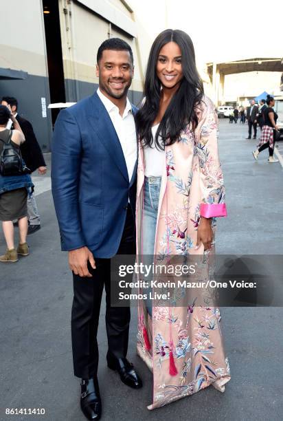 In this handout photo provided by One Voice: Somos Live!, NFL player Russell Wilson and singer Ciara pose backstage during "One Voice: Somos Live! A...