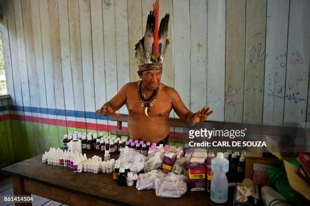 Chief Marcelino Apurina, of the Aldeia Novo Paraiso in the Western Amazon region of Brazil near Labrea stands by a table of modern medicines...