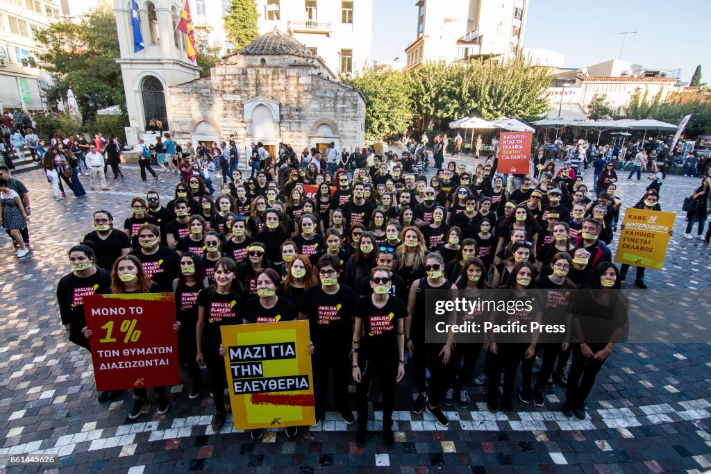 Athenians march silently wearing black outfit and yellow...