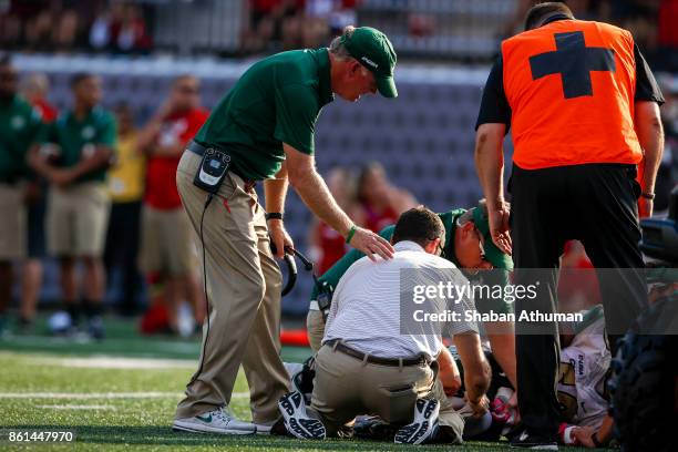 Head Coach Brad Lambert of the Charlotte 49ers looks after an injured Linebacker Karrington King against Western Kentucky University at L.T. Smith...