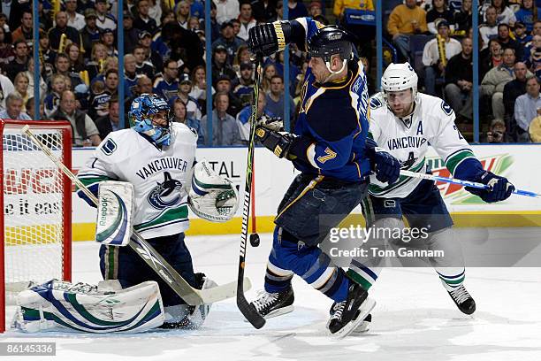 Keith Tkachuk of the St. Louis Blues redirects the puck as Roberto Luongo and Mattias Ohlund of the Vancouver Canucks defend during Game Four of the...