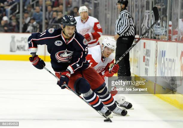 Fedor Tyutin of the Columbus Blue Jackets moves the puck up ice in front of Dan Cleary of the Detroit Red Wings during Game Three of the Western...