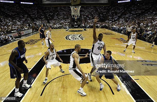 Guard Jose Juan Barea of the Dallas Mavericks drives the hoop against Kurt Thomas, Ime Udoka and Tony Parker of the San Antonio Spurs in Game One of...