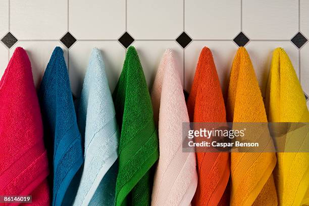 multi colored towels hanging in a row on the wall - towel stock pictures, royalty-free photos & images