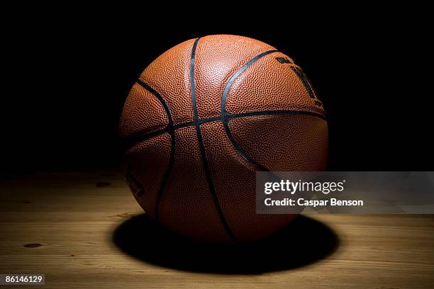 a spot lit basketball - basketball spielball stock-fotos und bilder