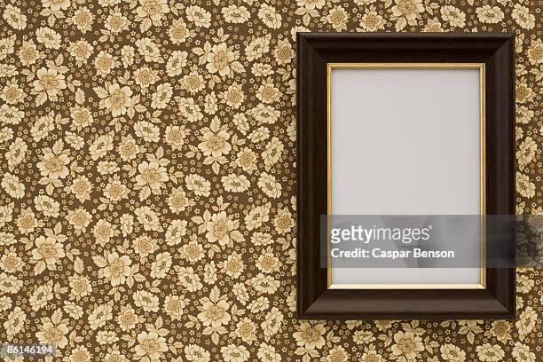 an empty frame hanging on wallpaper - picture frames on wall stock pictures, royalty-free photos & images