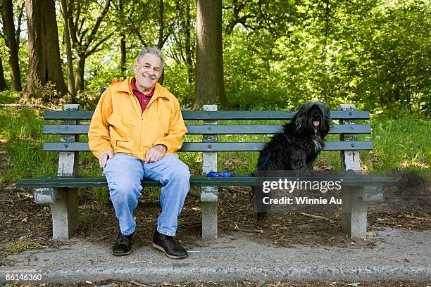 a man sitting with his dog on a park bench, prospect park, brooklyn, new york, usa - yellow coat 個照片及圖片檔