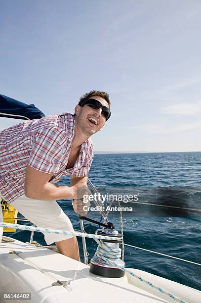 a man adjusting the rigging on a yacht - vinsch bildbanksfoton och bilder