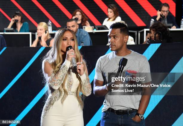 In this handout photo provided by One Voice: Somos Live!, singers Jennifer Lopez and Maxwell speak onstage during "One Voice: Somos Live! A Concert...