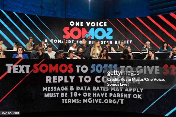 In this handout photo provided by One Voice: Somos Live!, actor Benicio del Toro and singer Jennifer Lopez speak onstage during "One Voice: Somos...