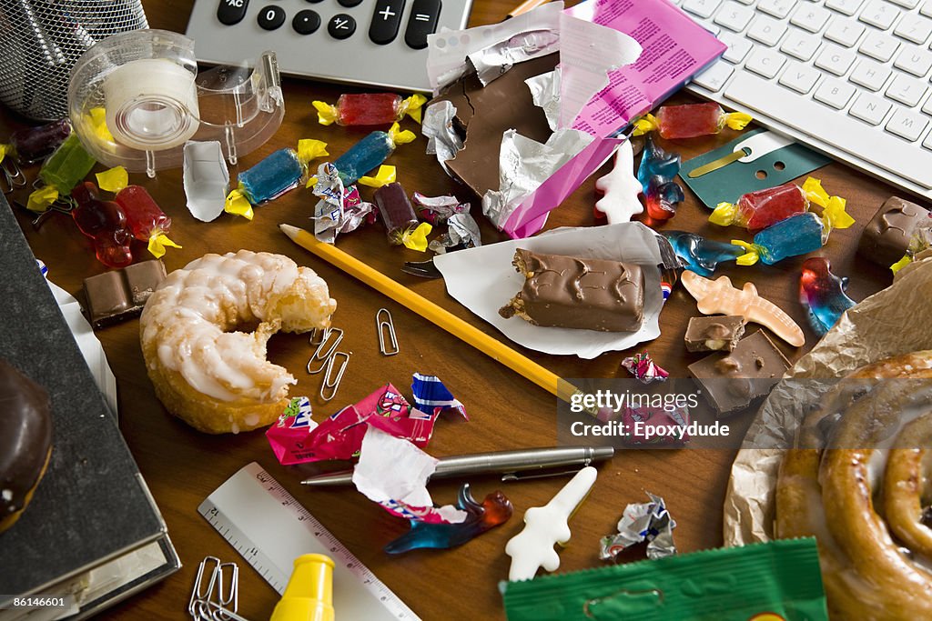 An office desk cluttered with candy and sweets