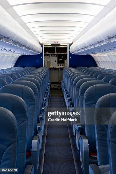 the empty cabin of an airplane - aisle seat airline stock-fotos und bilder