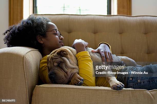 a young woman and her shar-pei napping on a couch - 動物の皮膚 ストックフォトと画像