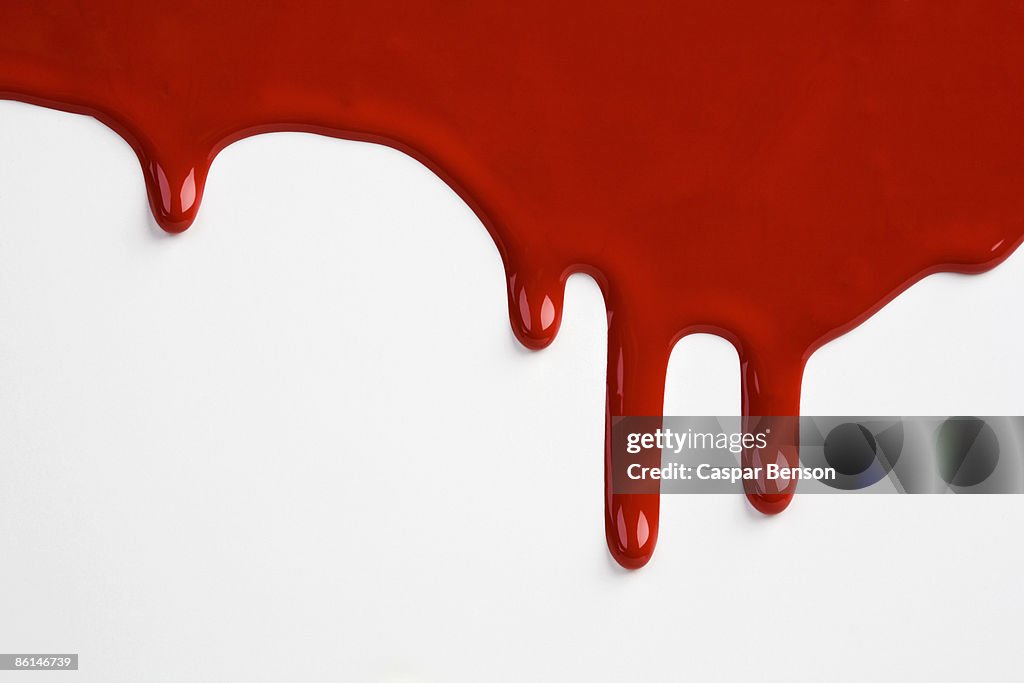 Red paint dripping down a white wall