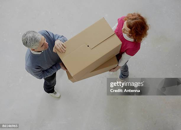 a couple carrying boxes together - moments daily life from above photos et images de collection