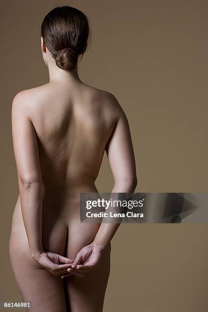 rear view of a nude woman standing - female backside - fotografias e filmes do acervo