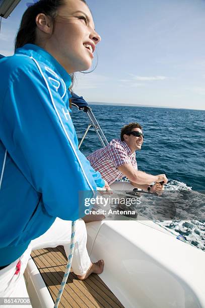 a couple adjusting the rigging on a yacht - vinsch bildbanksfoton och bilder