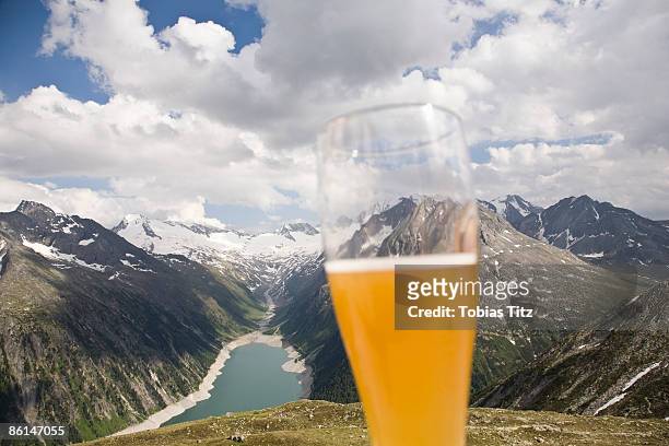 a beer glass in front of a view of the austrian alps - mountains alcohol snow bildbanksfoton och bilder