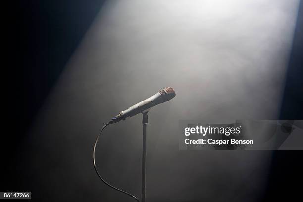 a spot lit microphone stand - microphone stand stock pictures, royalty-free photos & images