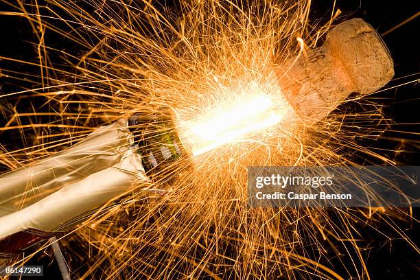 a champagne bottle opening with fireworks coming out - champagner korken stock-fotos und bilder