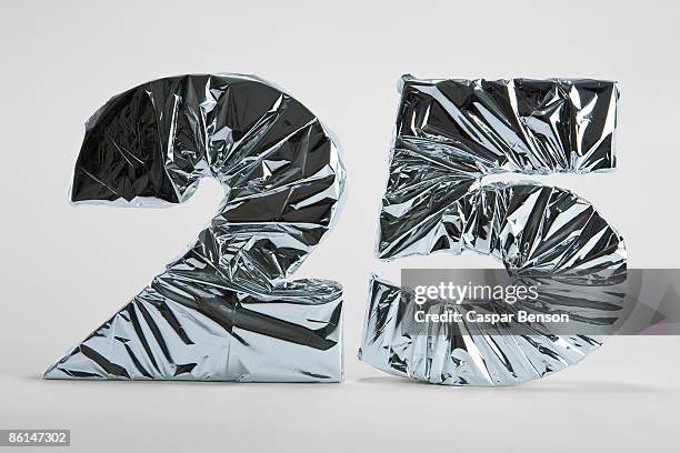 number 25 wrapped in silver foil - 25th anniversary foto e immagini stock