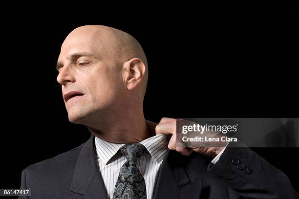 a business man pulling at his collar - kraag stockfoto's en -beelden