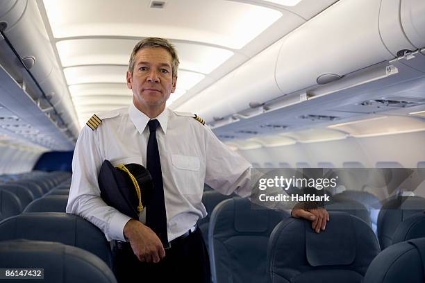 a pilot standing in the cabin of a plane - piloto fotografías e imágenes de stock