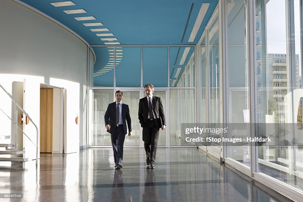 Two businessmen walking in the foyer of a convention center