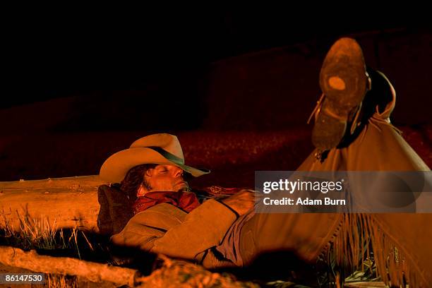 a cowboy sleeping next to a campfire - cowboy sleeping stock pictures, royalty-free photos & images