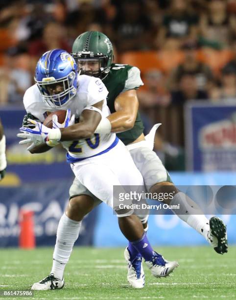 Malike Roberson of the San Jose State Spartans is tacked by Russell Williams Jr of the Hawaii Rainbow Warriors during the second quarter of their...