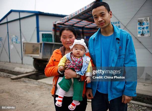 Chen Jiajia who was born on October 20 in a makeshift house after the earthquake, poses with his parents arms at Xinkai Village of Hanwang Township,...