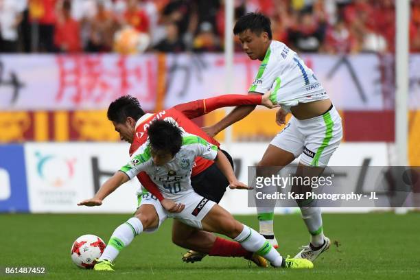 Keiji Tamada of Nagoya Grampus competes for the ball against Temma Matsuda and Miki Yamane of Shonan Bellmare during the J.League J2 match between...