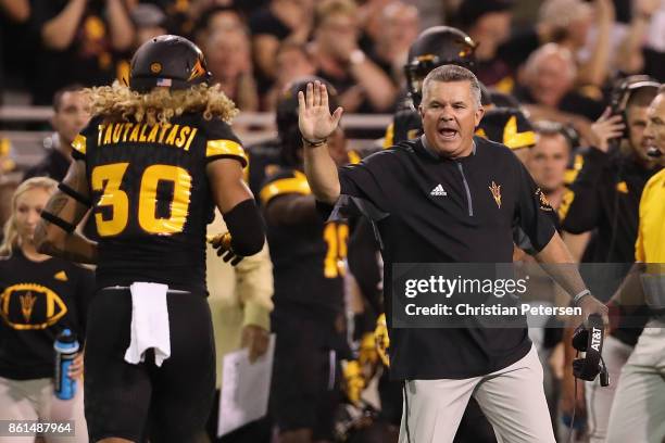 Head coach Todd Graham of the Arizona State Sun Devils celebrates with defensive back Dasmond Tautalatasi after the Washington Huskies missed a field...
