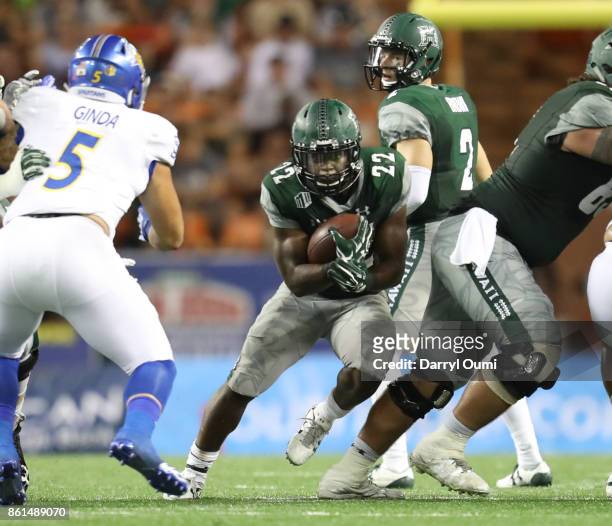 Diocemy Saint Juste of the Hawaii Rainbow Warriors finds a seam in the defense do run through during the third quarter of the game against the San...